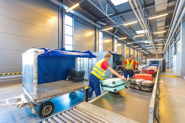 Workers at airport unloading baggage 